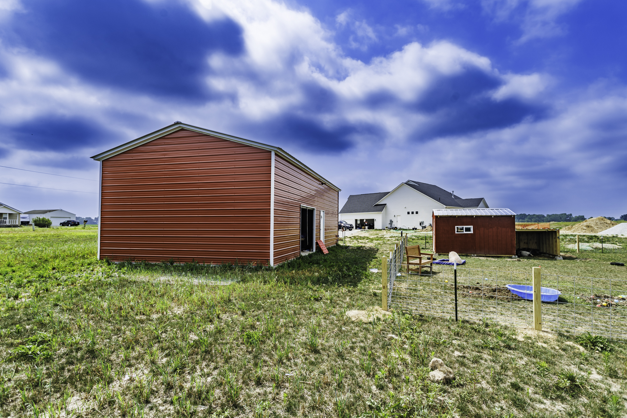 White and black steel building with walk-in door and window — side view